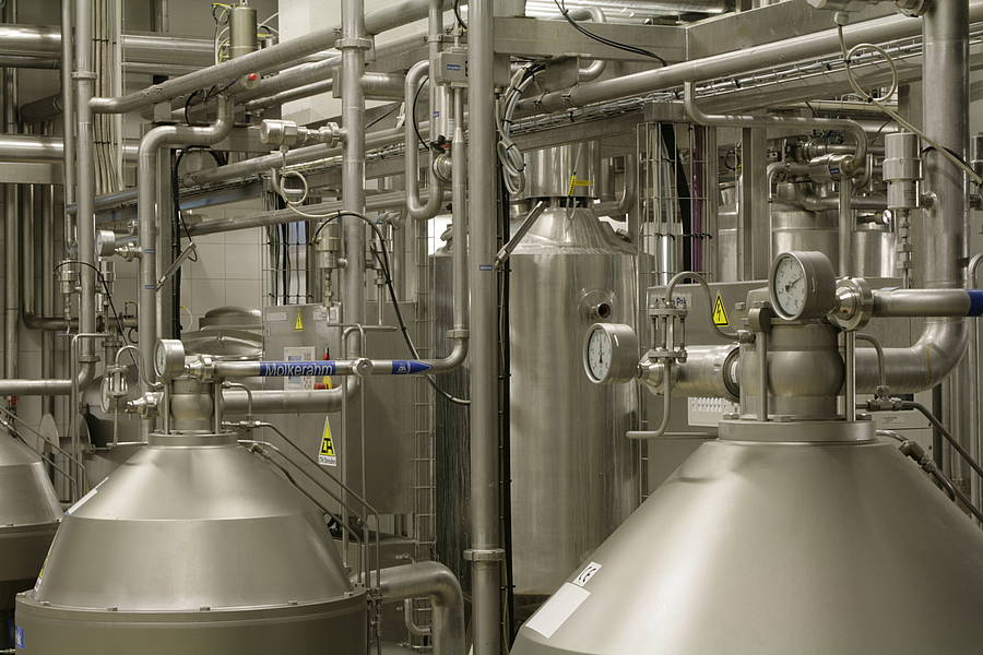 Ein großer Industrieaum mit sichtbaren Rohren und Ventilen, die die technische Ausstattung des Raumes zeigen